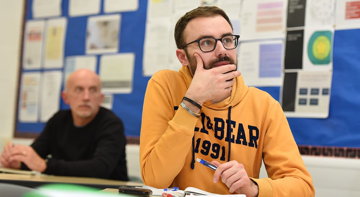 Adult Education students listening to tutor in a classroom