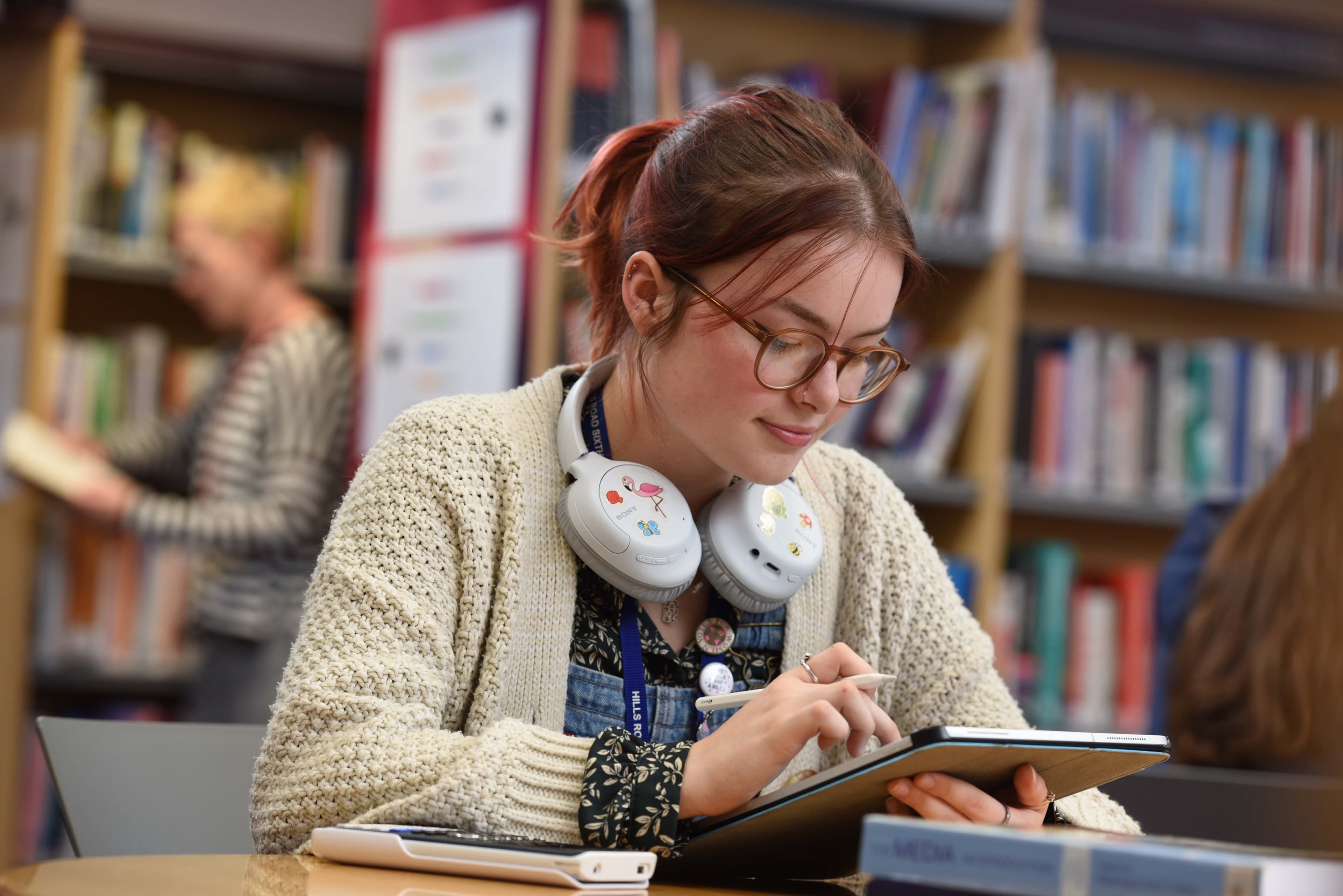 Student studying on iPad in the library