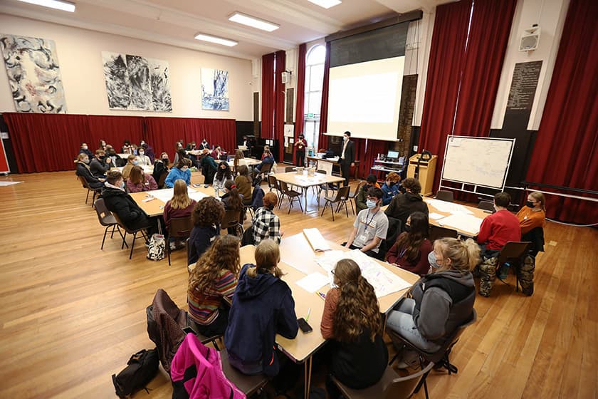 People sitting around tables in the Hall