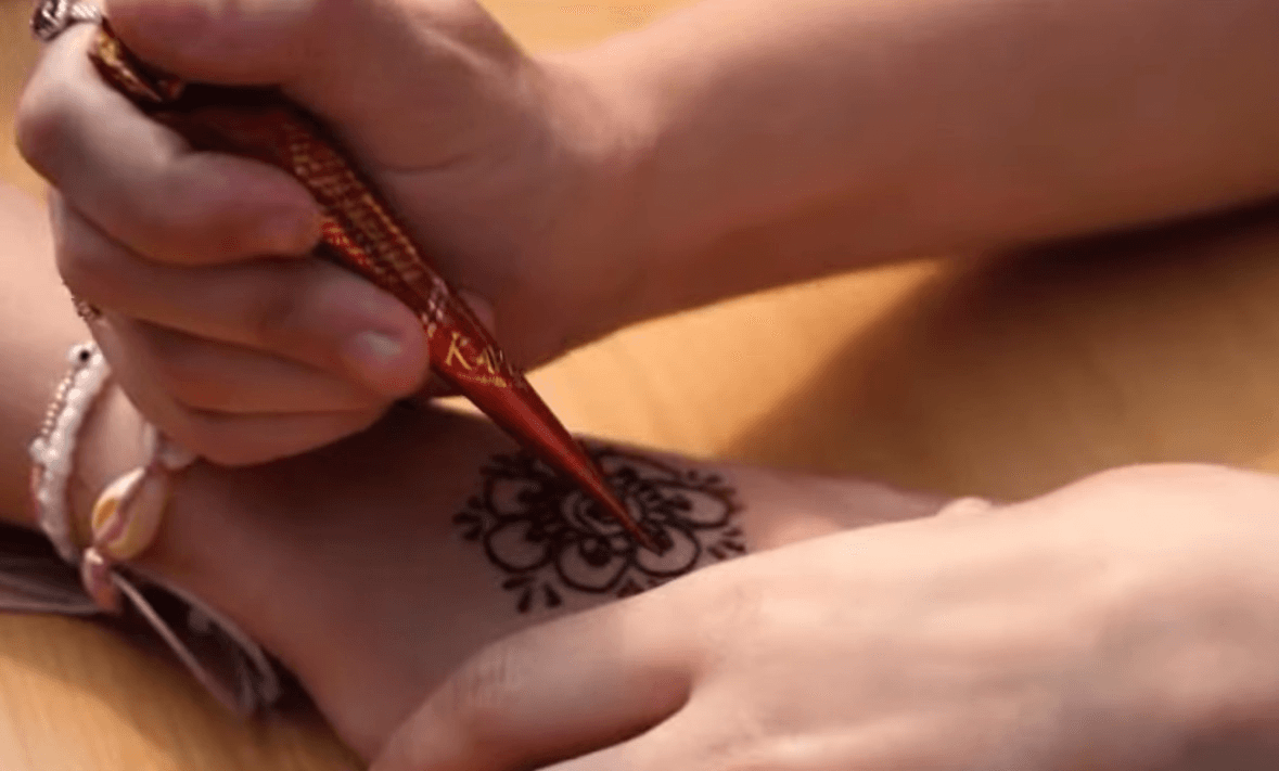 Member of the South Asian Society applying Henna to another student at Culture Fest 2025
