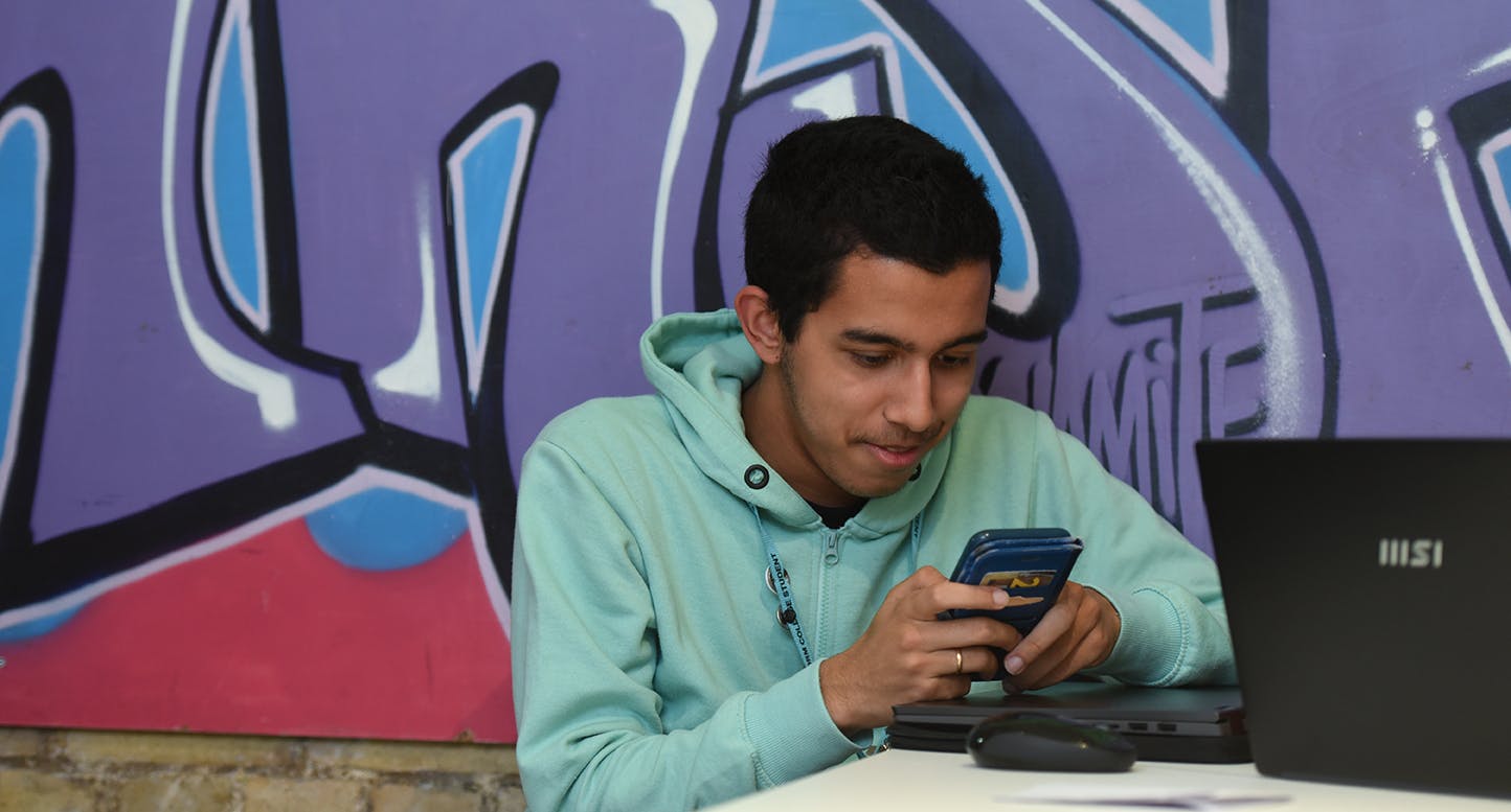 Student sitting looking at his phone