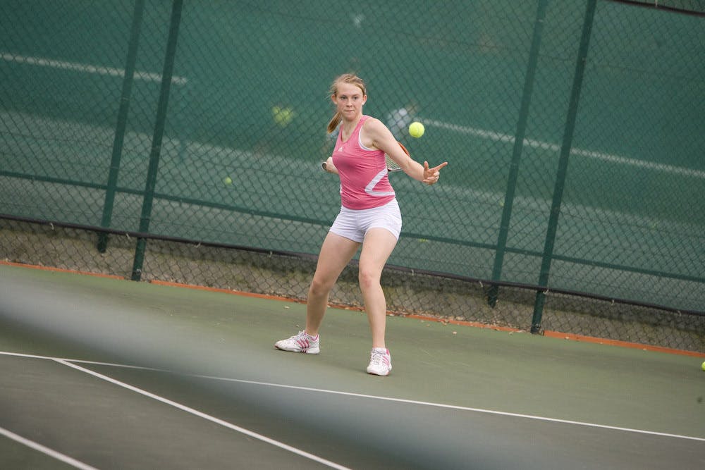 Student playing tennis on one of the outdoor tennis courts