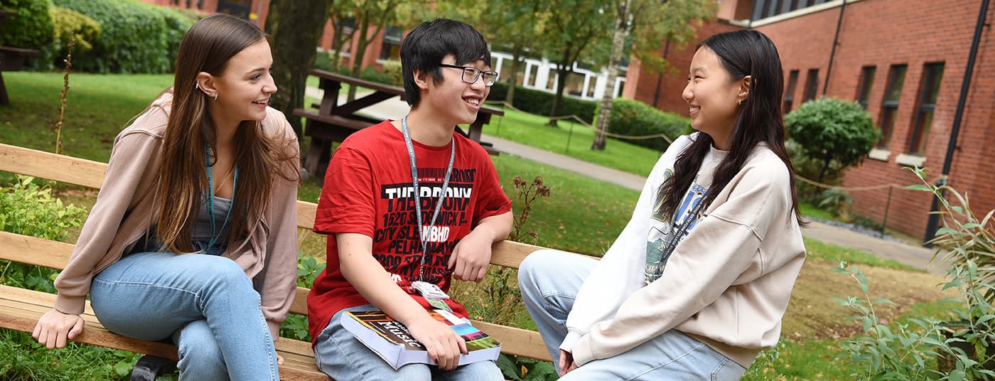 Three students chatting by tranquillity garden